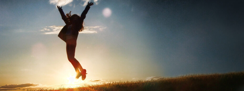 A woman jumping in the air on a sunny day