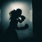 Young woman boxer with dramatic lighting