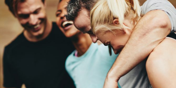 Diverse group of fit friends laughing together at the gym