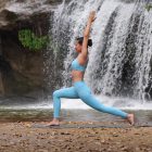 Woman doing a yoga flow in front of a waterfall