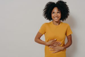 Happy woman with hands on stomach