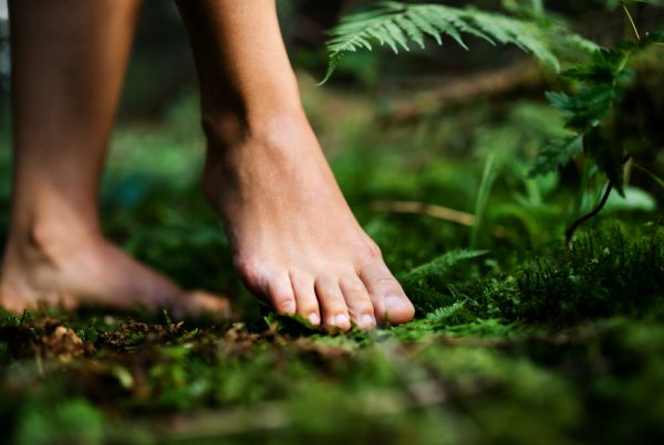 Bare feet of woman standing barefoot outdoors in nature