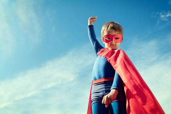 Superhero kid in red cape and mask