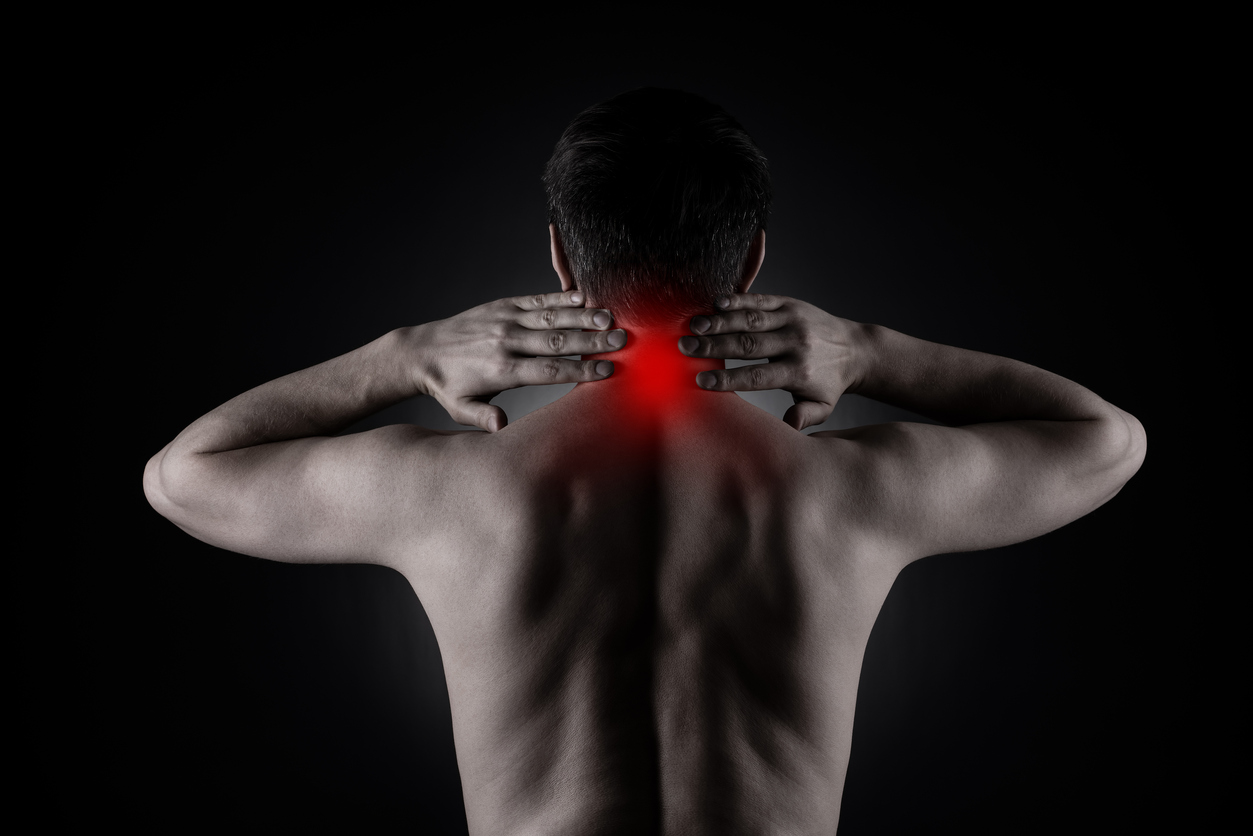 How to help clients with their pain - black and white image of the back of a man with a red zone of pain at his neck