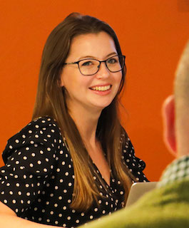 Headshot of Jess Gibbs with orange background