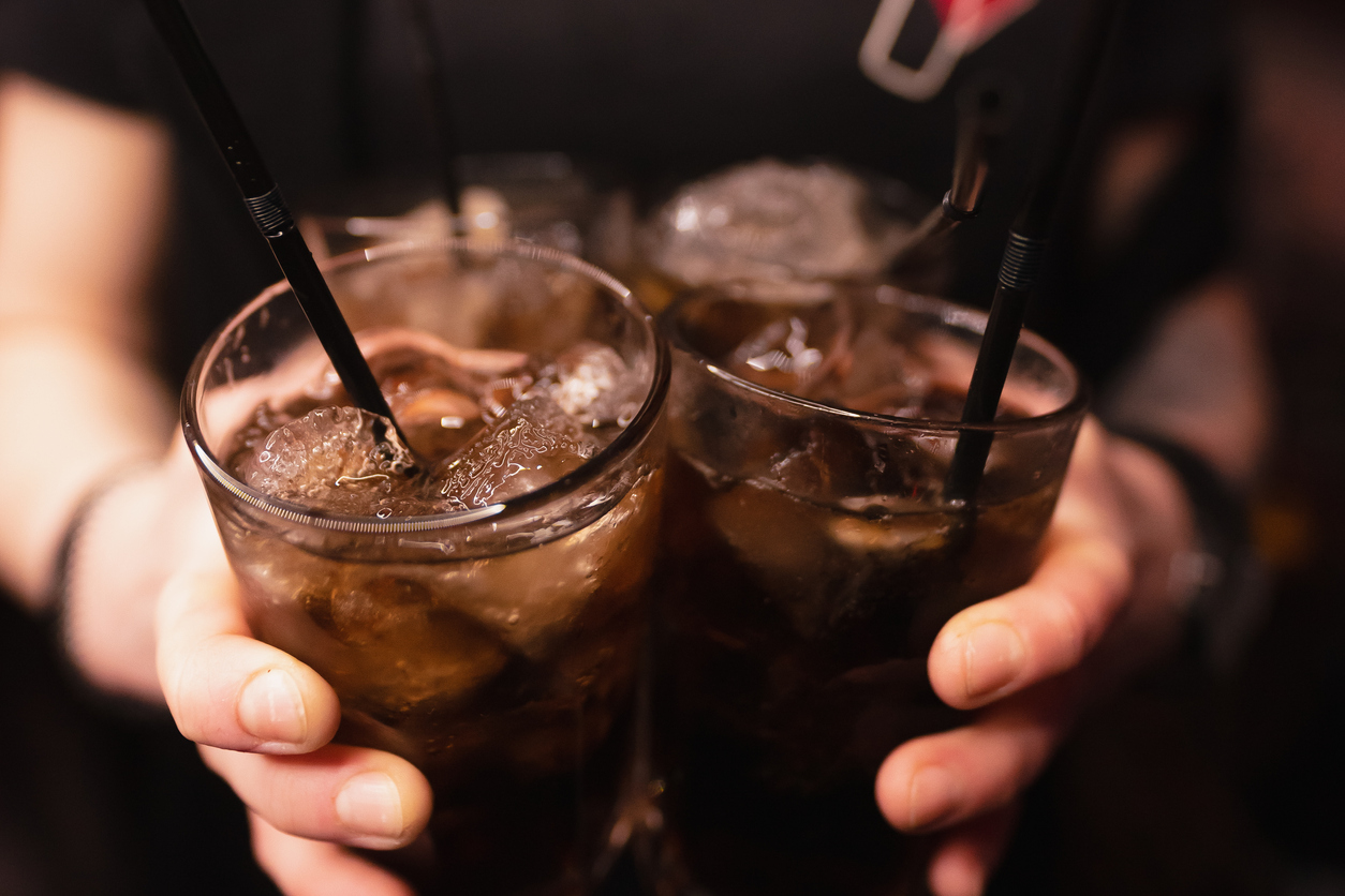 Diet drinks - Image of bartender holding 2 glasses full of drinks with ice cubes and straw