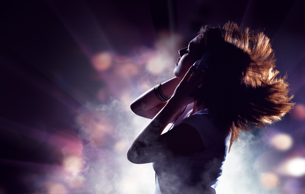 fitness music - Image showing silhouette of a girl with hair blowing in the wind listening to music