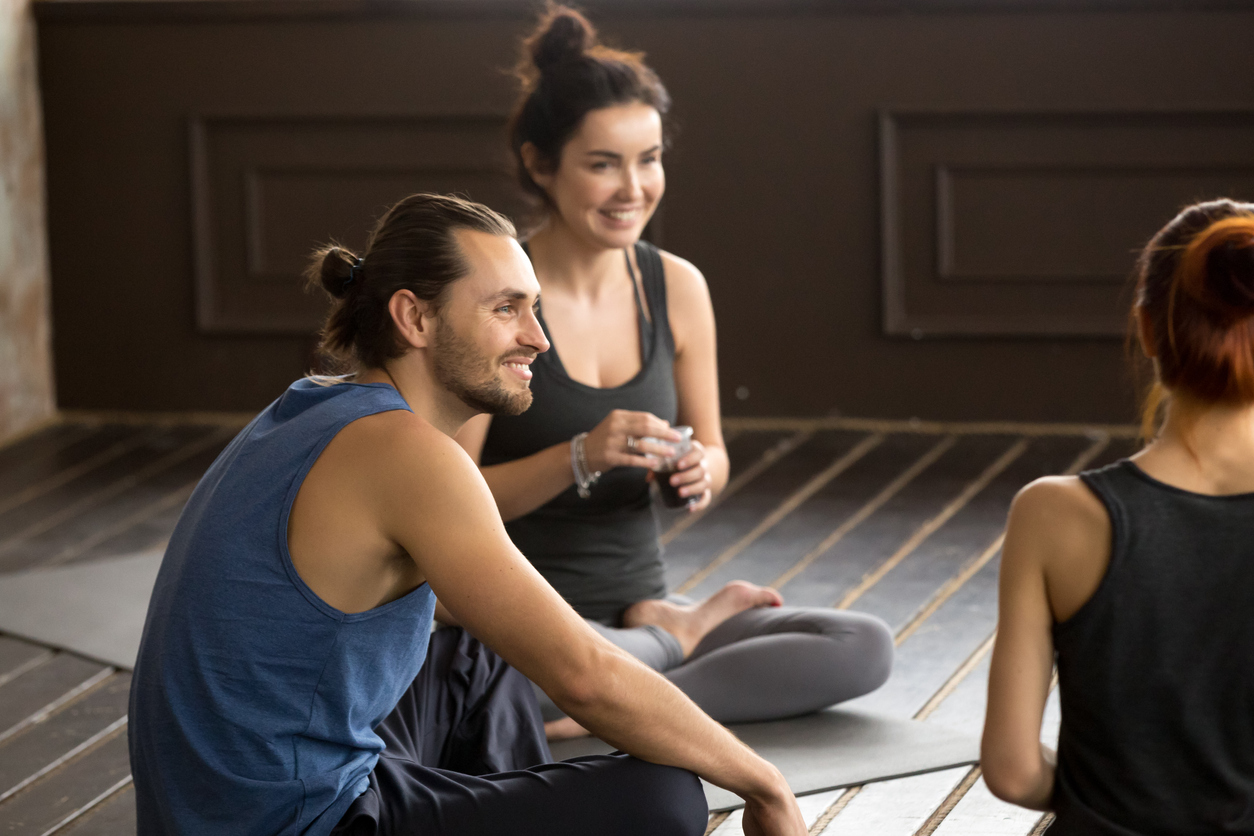 The art of teaching mixed-level classes _ image of smiling mindful yogi man sitting on mat at group training