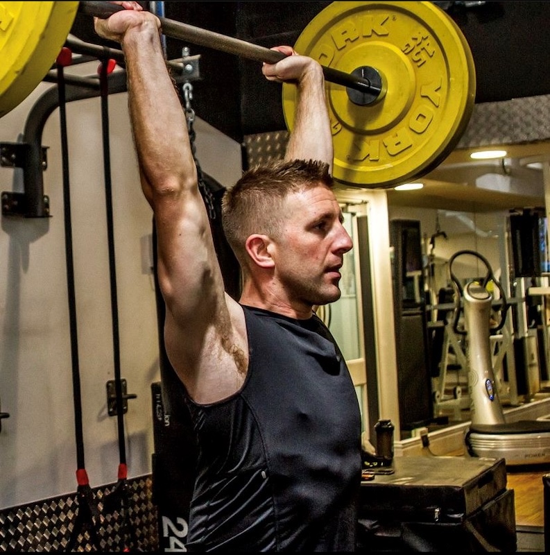 Strength training principles - Image of Stu Gatherum with a barbell pressed above his head