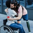 Accessible and inclusive - Image of friends with different disabilities hugging each other outdoors.
