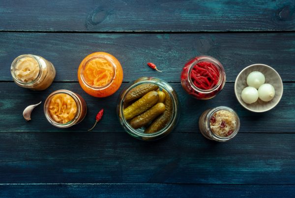 Fermented foods pictured from overhead. Homemade vegetable preserves, Sauerkraut, pickles, kimchi etc in glass jars. Image is to depict healthy probiotic and prebiotic diet and supplements.
