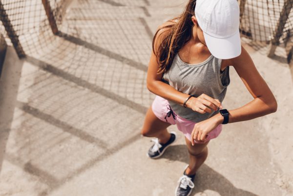 Top fitness trends for 2024 - Image of female runner looking at smart watch heart rate monitor
