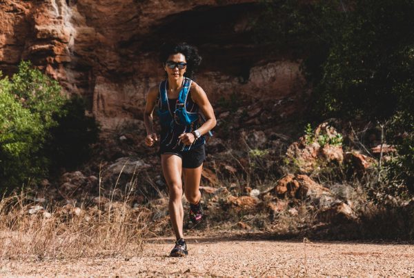 altitude training - woman ultra trail marathon runner running through the rock mountain