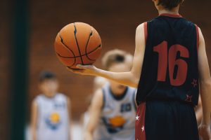 Youth athletic development - Young basketball player with classic ball.