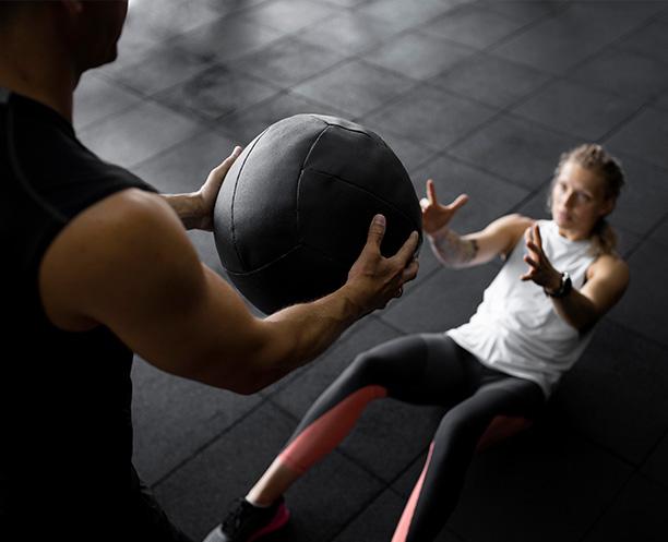 personal trainer and client with medicine ball