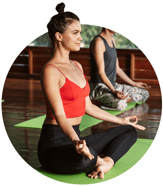 2 people sat on a mats performing yoga