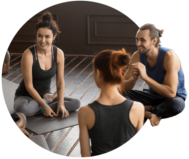 Pilates exercise class sat in a circle on exercise mats