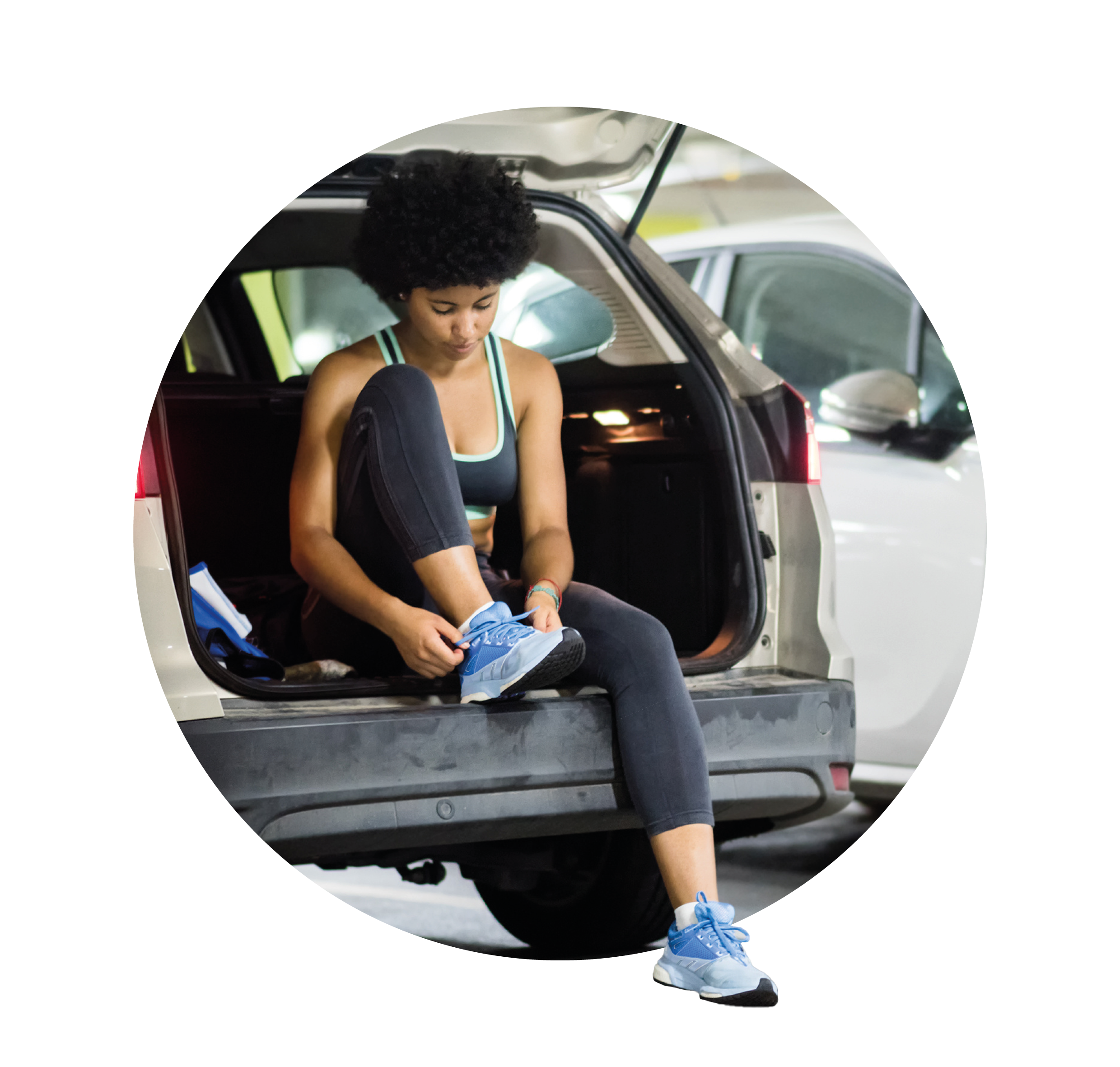 woman sat in car boot tying trainers